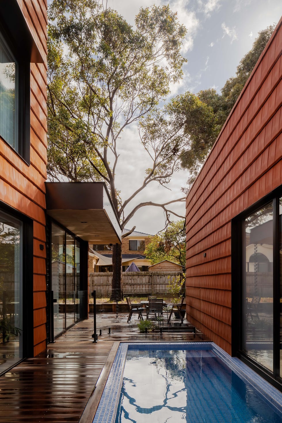 casa sostenible de arquitectos viven tres generaciones que se organizan en torno a un patio, tres arboles y una piscina