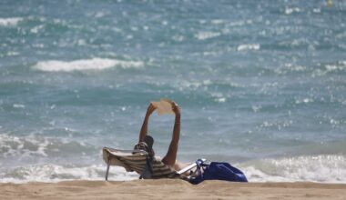 Una persona legge in spiaggia a Maiorca nel 2020 (Clara Margais/Getty Images)