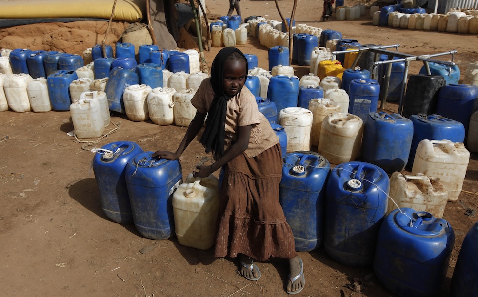 Una bambina raccoglie acqua al campo di Zamzam nel 2010
