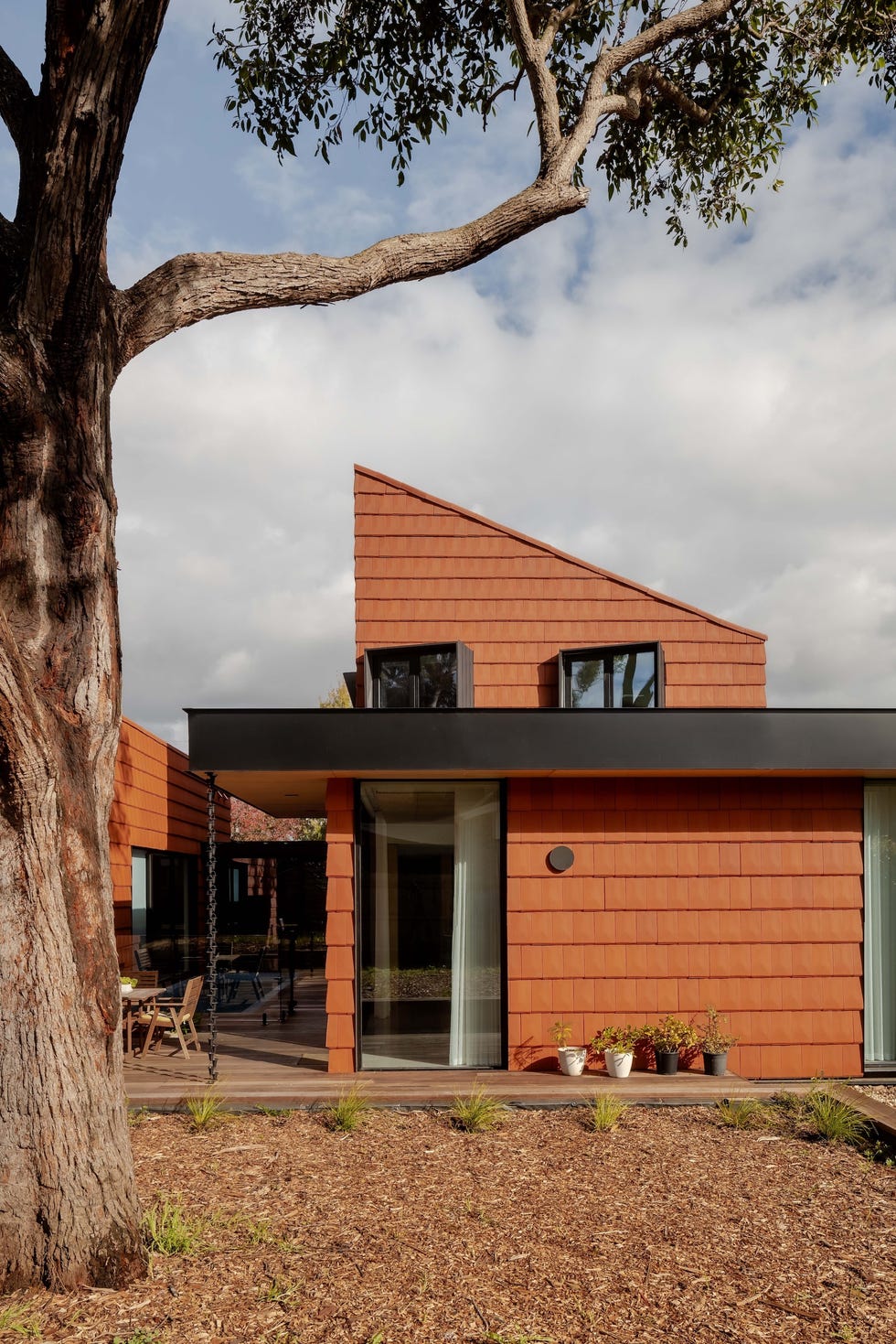 casa sostenible de arquitectos viven tres generaciones que se organizan en torno a un patio, tres arboles y una piscina