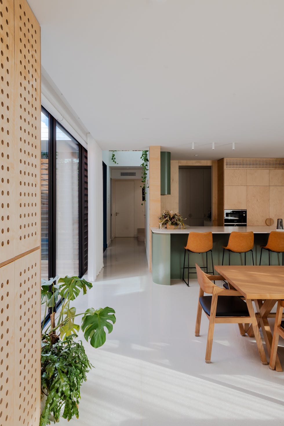 casa sostenible de arquitectos viven tres generaciones que se organizan en torno a un patio, tres arboles y una piscina