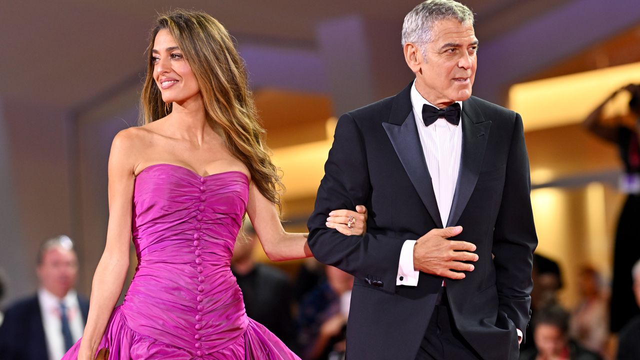 Amal Clooney al Festival di Venezia 2025 cattura i flash con l'abito croccante ciclamino dal maxi strascico balloon