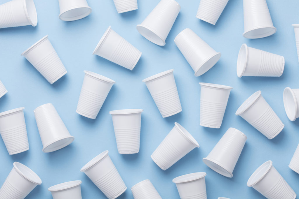 Bicchieri di plastica monouso su sfondo azzurro