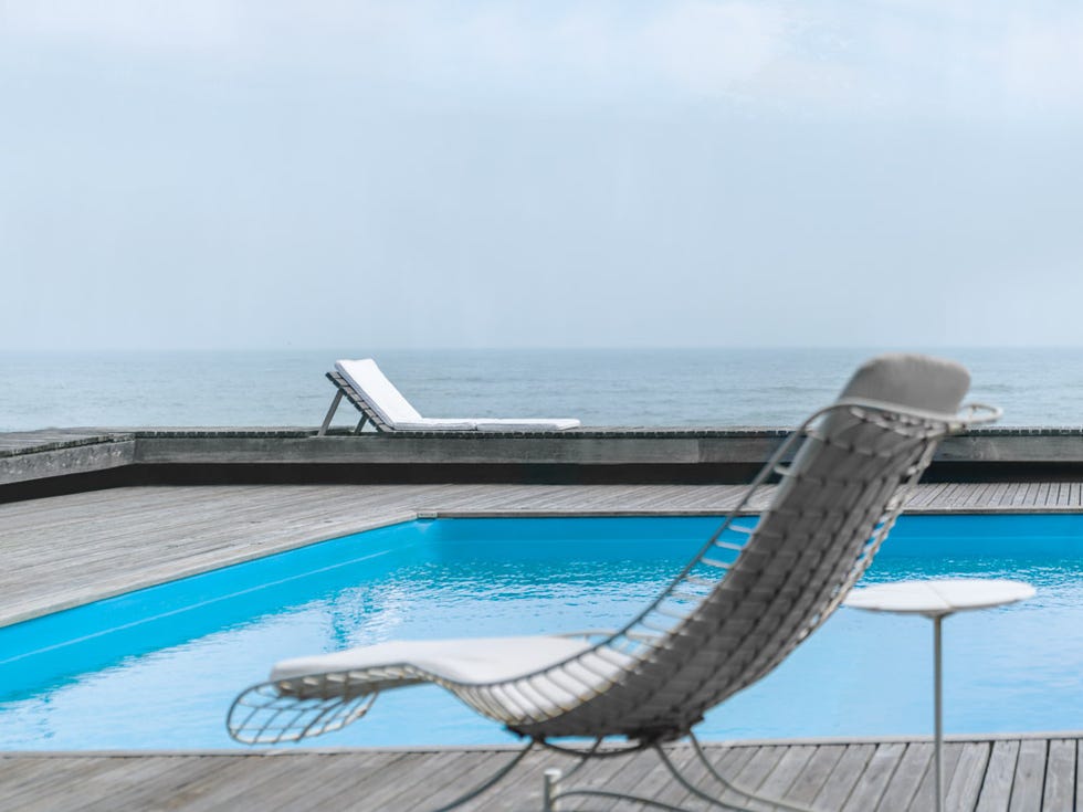 lounge chairs by a swimming pool overlooking the ocean