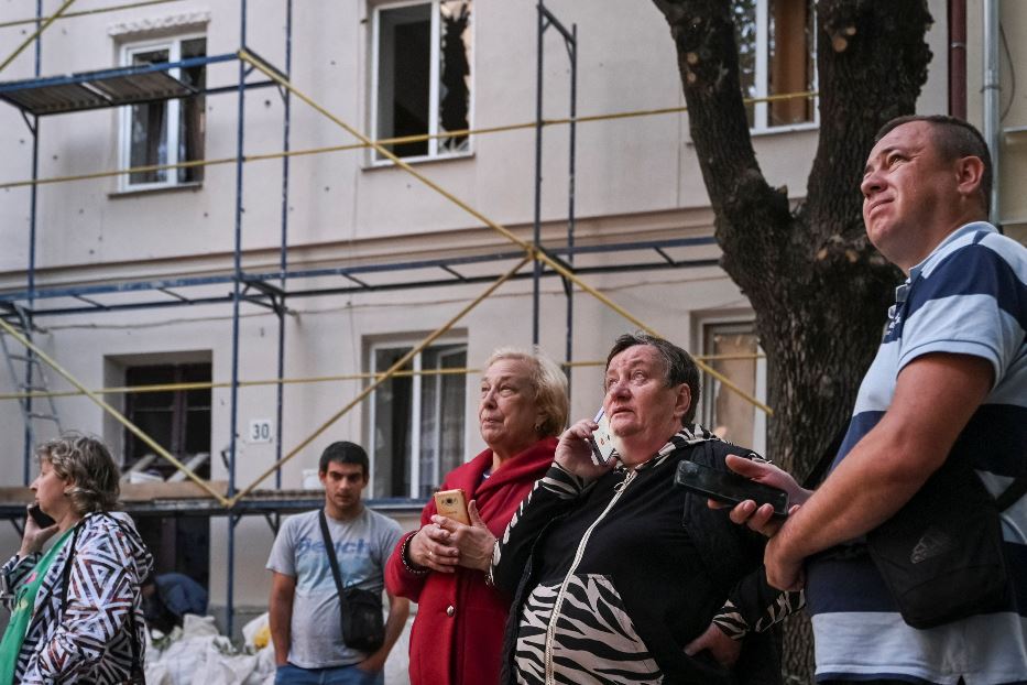 Alcuni abitanti di Liv guardano le loro case distrutte dopo un raid russo