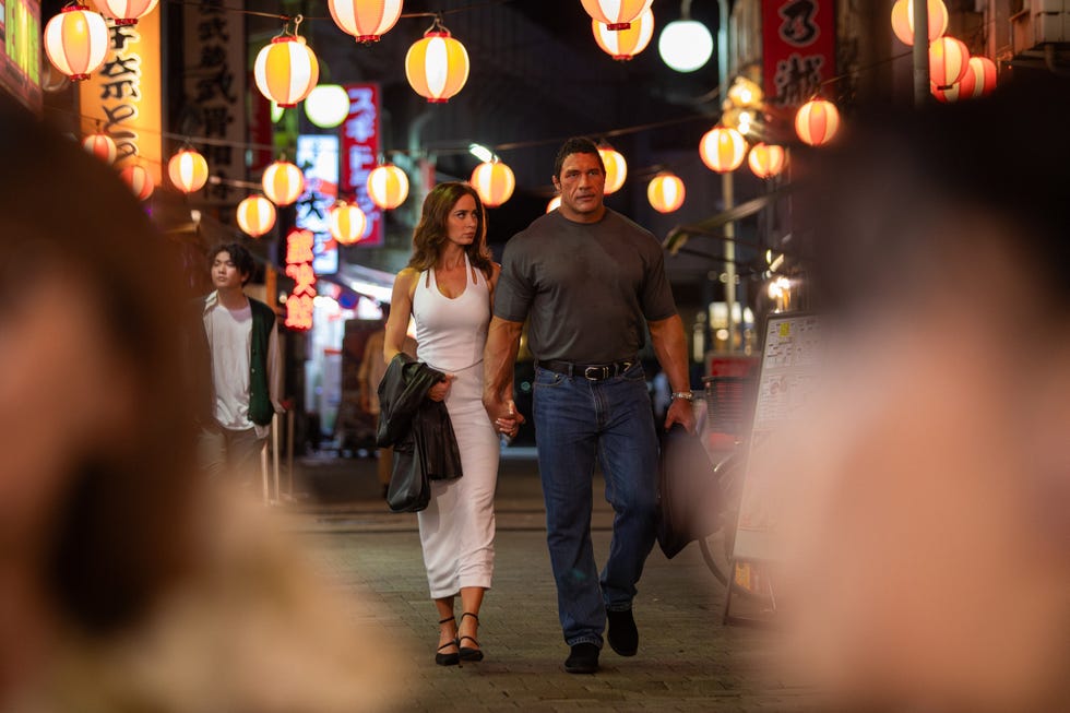 a couple walking handinhand through a vibrant night market street adorned with lanterns