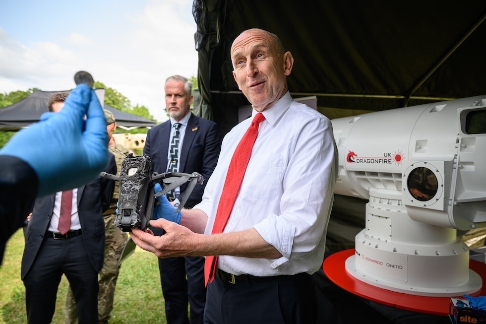 Il ministro della Difesa britannico, John Healey, regge un drone abbattuto dal sistema di difesa laser Dragonfire, che l'esercito britannico sta sviluppando