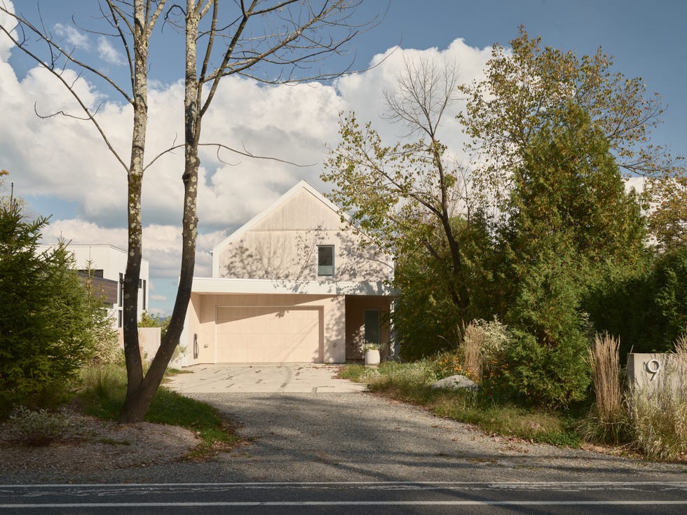 casa blanca por un lado se abre a un lago y por otro parece tipica casa de campo