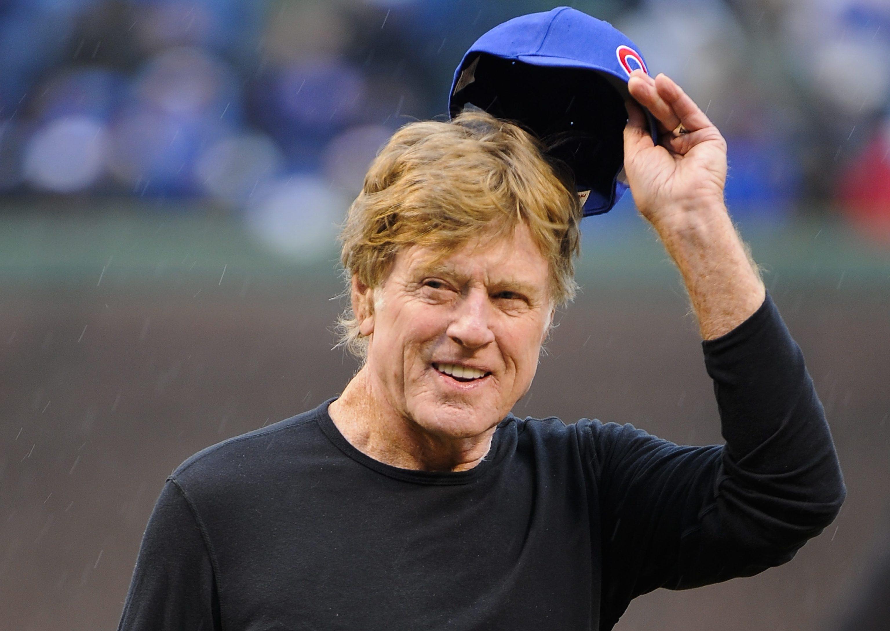 epa02664988 US actor and director Robert Redford tips his hat before throwing out the first pitch before the first inning of the Pittsburgh Pirates at Chicago Cubs baseball game at Wrigley Field in Chicago, Illinois, USA 01 April 2011.  EPA/TANNEN...