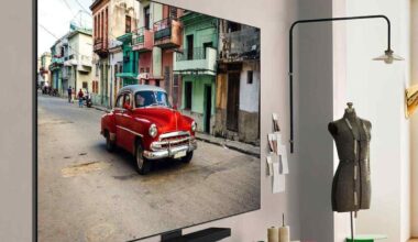 smart tv LG OLED evo AI C5 appesa alla parete con un'auto rossa sul display