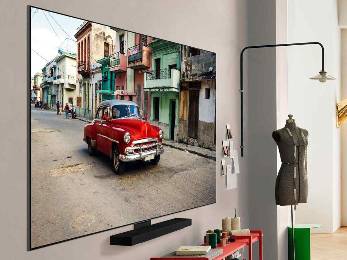 smart tv LG OLED evo AI C5 appesa alla parete con un'auto rossa sul display