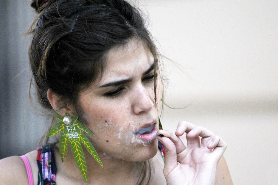 Una giovane donna fuma cannabis durante una manifestazione a favore della legalizzazione in Cile