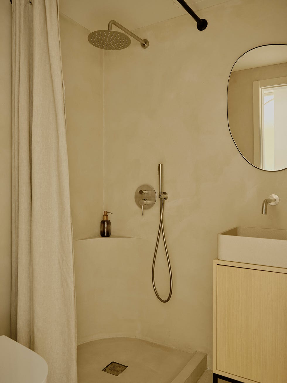 un piso mini con dormitorio en color arena y aseo ducha en microcemento pulido
