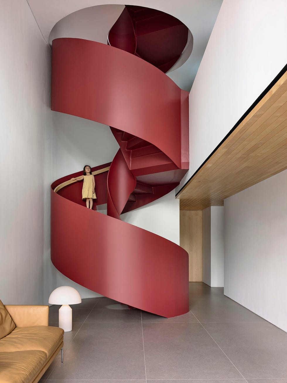 spiral staircase in a modern interior setting with a small figure on the stairs