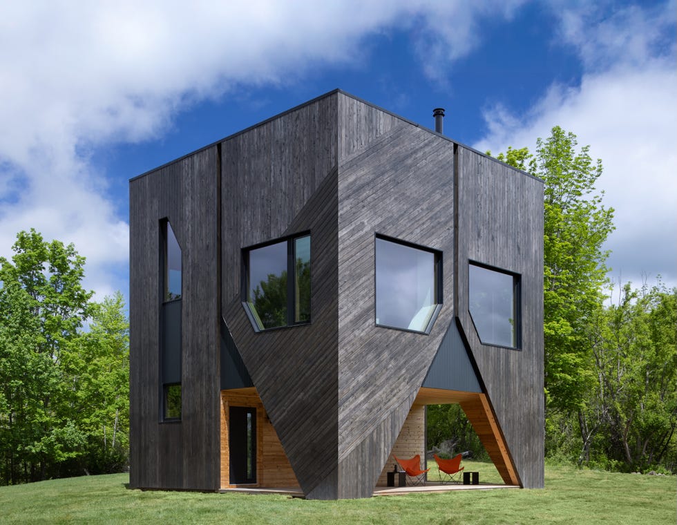 casa cabana de madera de cedro cubo negro que cambia y esta en lo alto de una colina