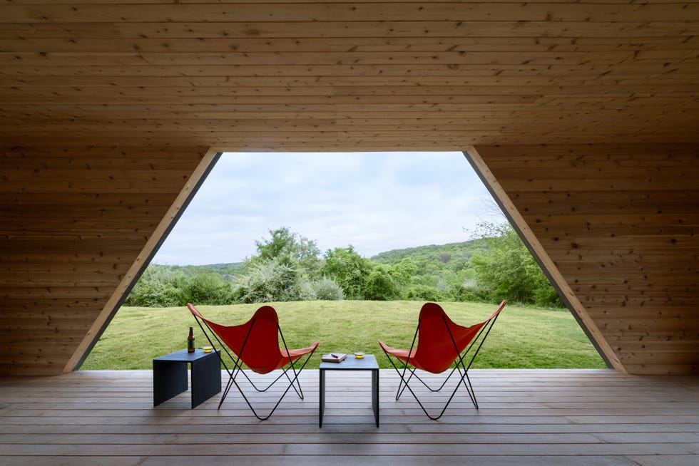 casa cabana de madera de cedro cubo negro que cambia y esta en lo alto de una colina