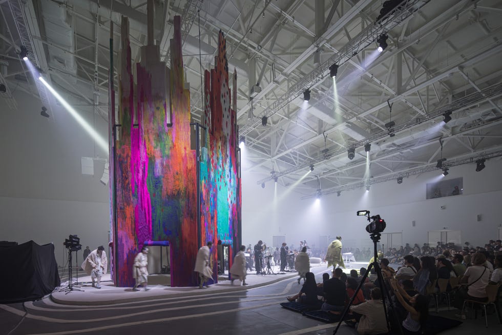 performance space featuring a vibrant artistic installation with performers and an audience