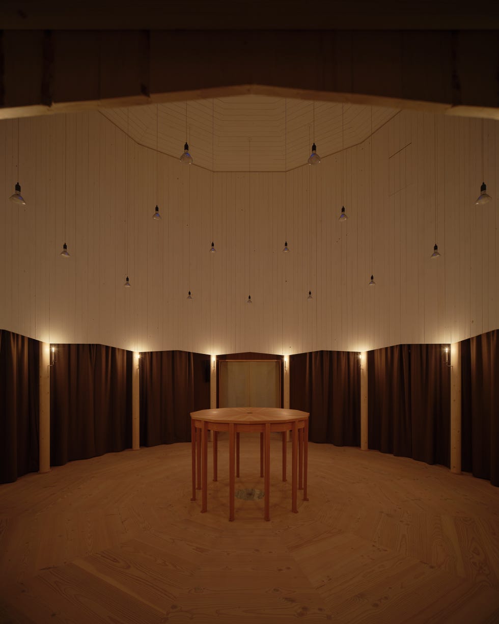 interior space featuring a circular wooden table surrounded by dark curtains