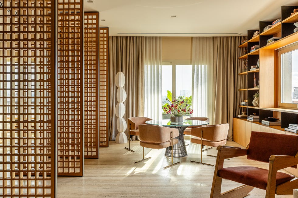 paneles pivotantes de madera definen los espacios de esta casa que ha mantenido algunos de sus elementos originales y tiene un balcon precioso
