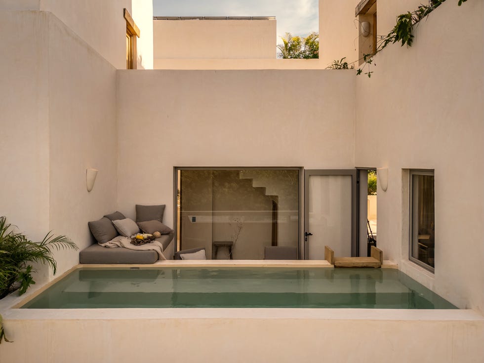 complejo residencial que se disuelve en la selva con terrazas escalonadas, muros de chukum y la estetica de la ruina reinterpretada