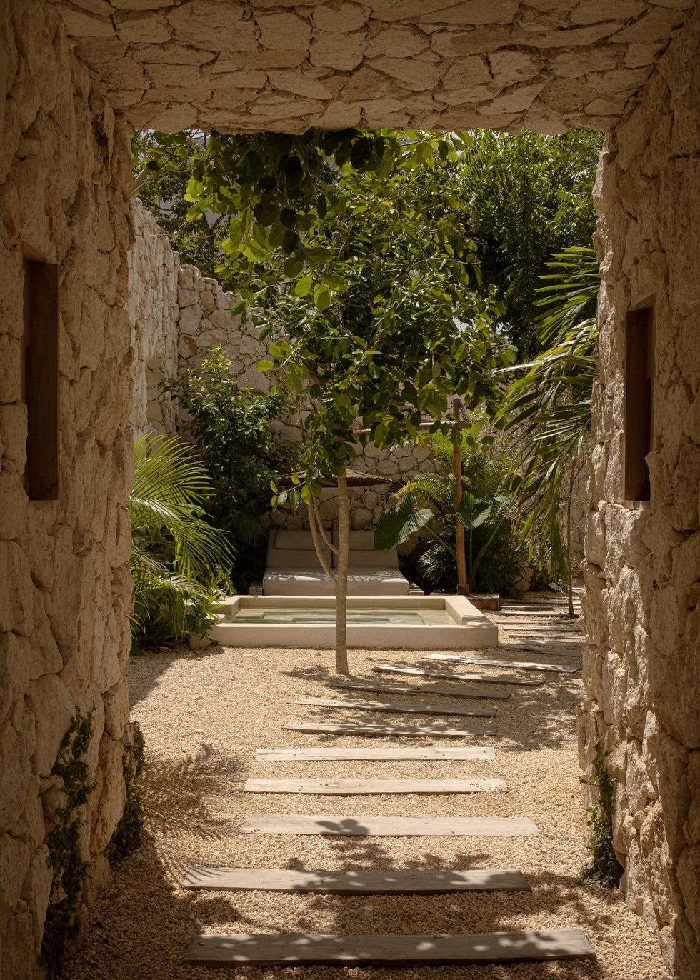 complejo residencial que se disuelve en la selva con terrazas escalonadas, muros de chukum y la estetica de la ruina reinterpretada