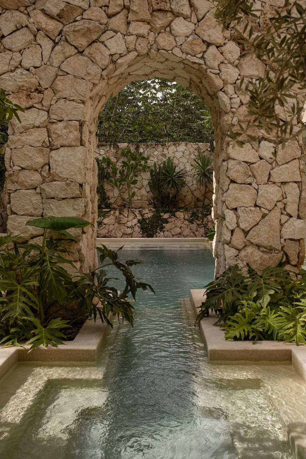 complejo residencial que se disuelve en la selva con terrazas escalonadas, muros de chukum y la estetica de la ruina reinterpretada