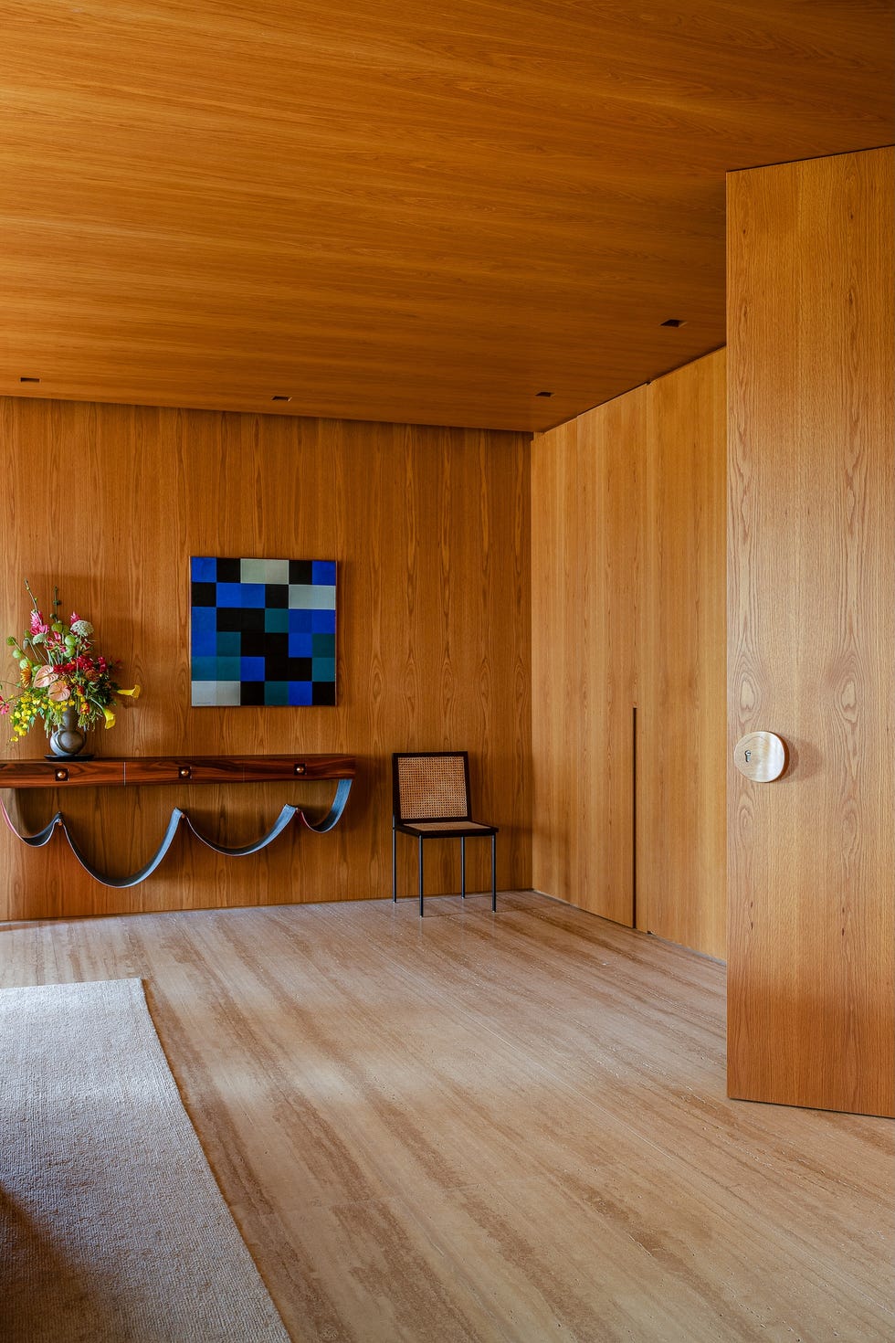 paneles pivotantes de madera definen los espacios de esta casa que ha mantenido algunos de sus elementos originales y tiene un balcon precioso