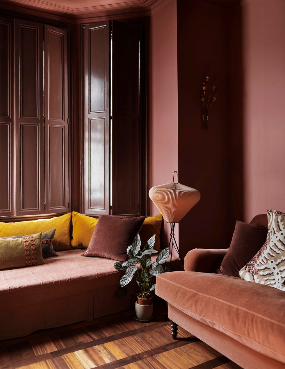 moody sitting room in rich mauve colour with velvet sofa