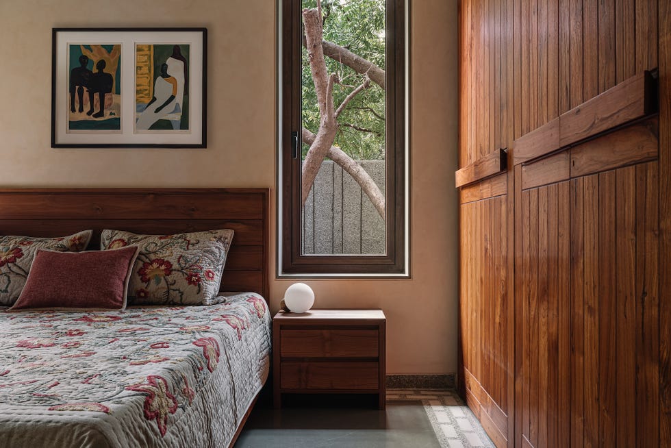 cozy bedroom featuring art wooden furniture and a window with greenery outside
