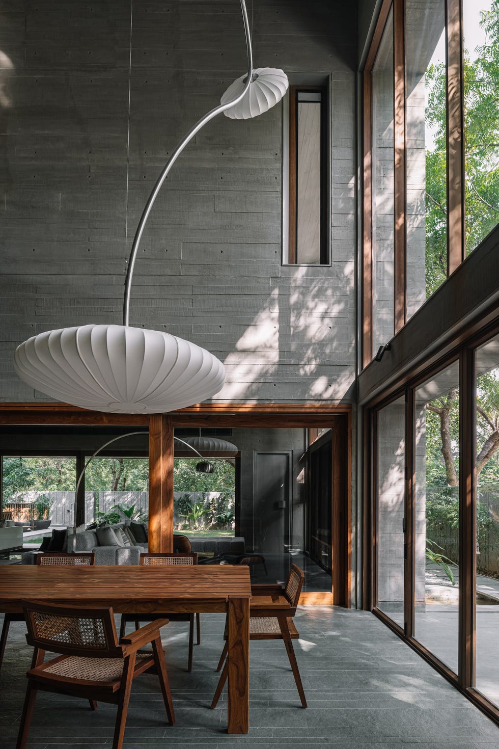 interno di casa brutalista con dettagli in legno e lampada scultorea in carta