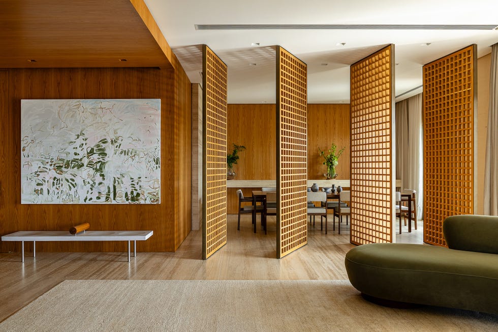 paneles pivotantes de madera definen los espacios de esta casa que ha mantenido algunos de sus elementos originales y tiene un balcon precioso