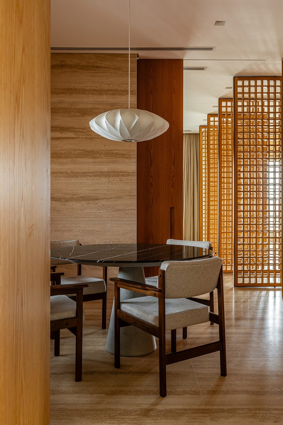 paneles pivotantes de madera definen los espacios de esta casa que ha mantenido algunos de sus elementos originales y tiene un balcon precioso