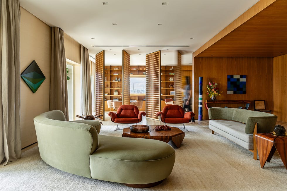 paneles pivotantes de madera definen los espacios de esta casa que ha mantenido algunos de sus elementos originales y tiene un balcon precioso