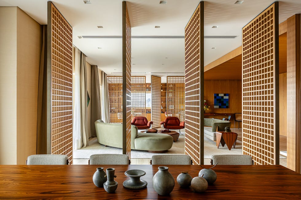 paneles pivotantes de madera definen los espacios de esta casa que ha mantenido algunos de sus elementos originales y tiene un balcon precioso