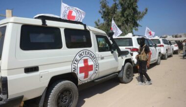 Un miliziano palestinese di Hamas in piedi di fronte ai veicoli del convoglio internazionale della Croce Rossa, nel sud della Striscia di Gaza