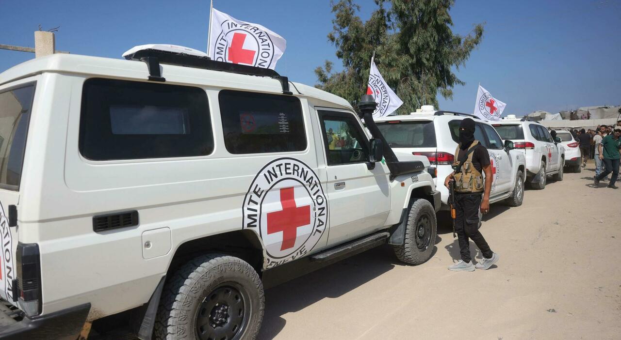 Un miliziano palestinese di Hamas in piedi di fronte ai veicoli del convoglio internazionale della Croce Rossa, nel sud della Striscia di Gaza