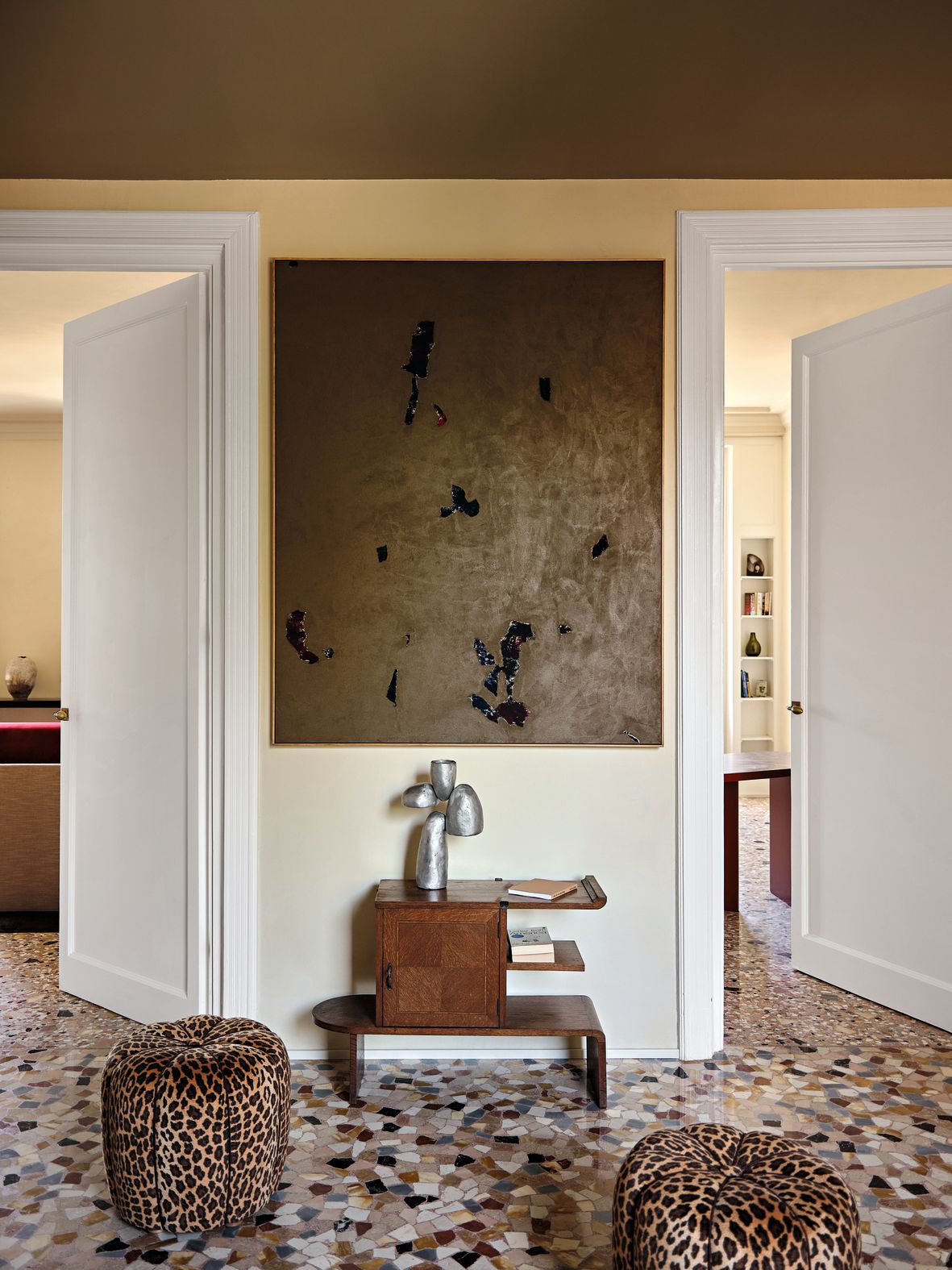 Ingresso pouf leopardati mobiletto in legno scultura in metallo dipinto astratto porte bianche
