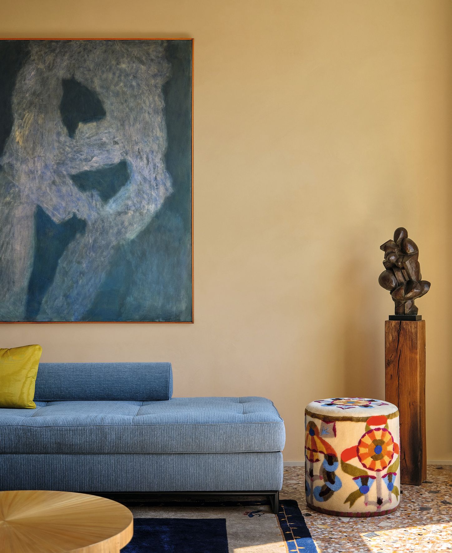 Divano celeste pouf con disegni colorati piedistallo in legno scultura astratta tavolino tondo in legno pareti gialle...