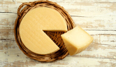 Forma di formaggio su un vassoio di vimini con una fetta tagliata