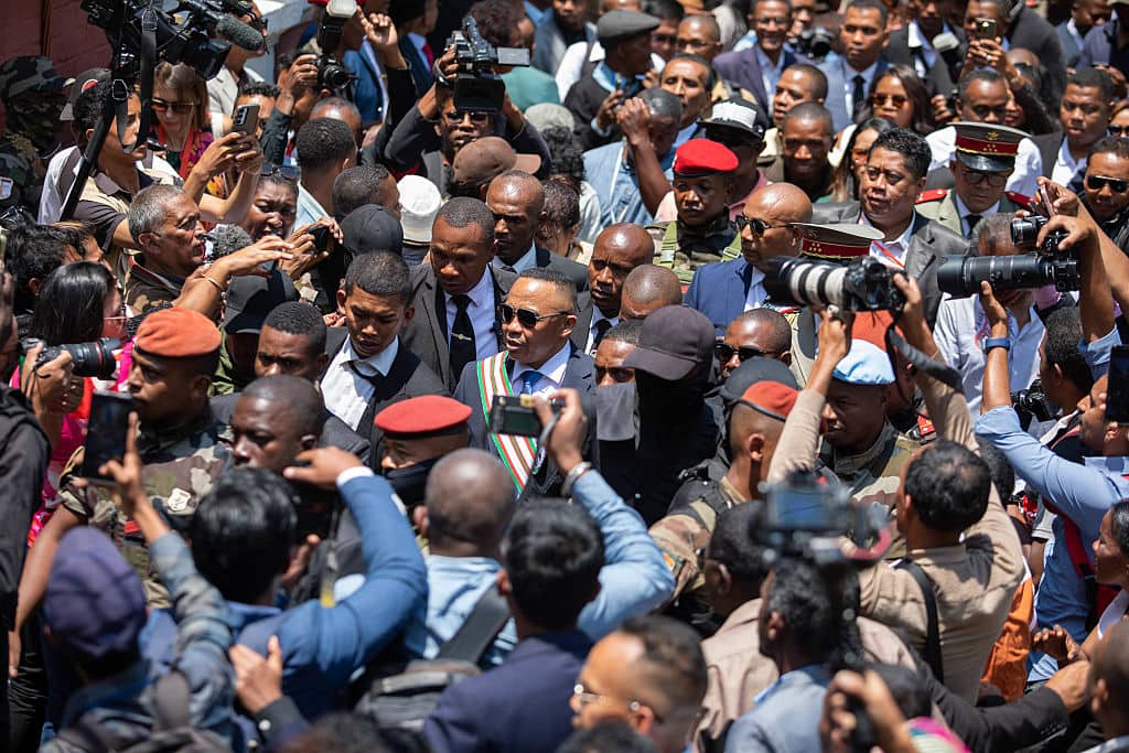TOPSHOT - Newly sworn in President of Madagascar Michael Randrianirina (C) is surrounded by a crowd of people as he leaves following his swearing in ceremony in Antananarivo on October 17, 2025. Army colonel Michael Randrianirina was sworn in as Madagascar's president on October 17, 2025, just days after a military power grab that sent ex-president Andry Rajoelina fleeing and raised international alarm about a new coup on the island.
Randrianirina led the CAPSAT army unit that mutinied and joined anti-government protesters before announcing the military had taken over after Rajoelina was impeached for desertion of duty on Tuesday. (Photo by Mamyrael / AFP) (Photo by MAMYRAEL/AFP via Getty Images)          