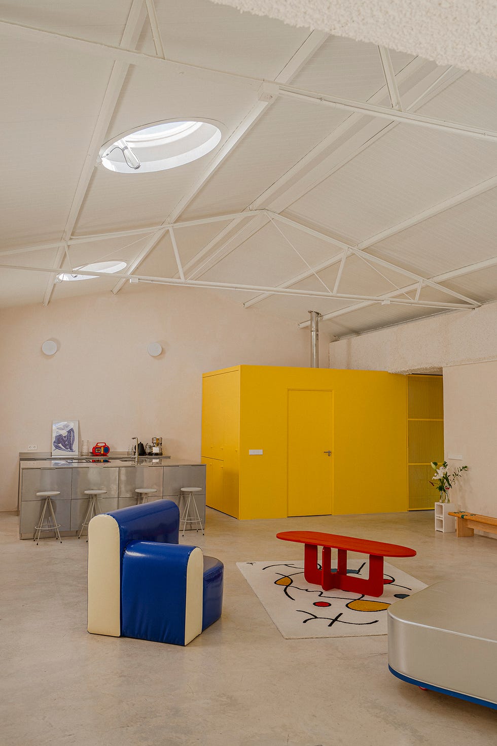 casa taller con techos a dos aguas y muebles modernos de colores