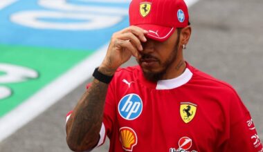 Hamilton dipping his Ferrari cap sombrely, partially hiding his face