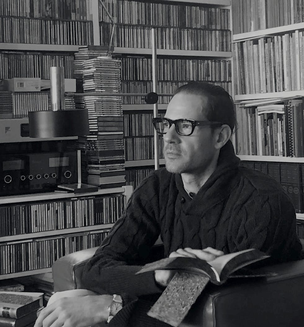 a person sitting in a cozy environment surrounded by books and cds a person sitting in a cozy environment surrounded by books and cds