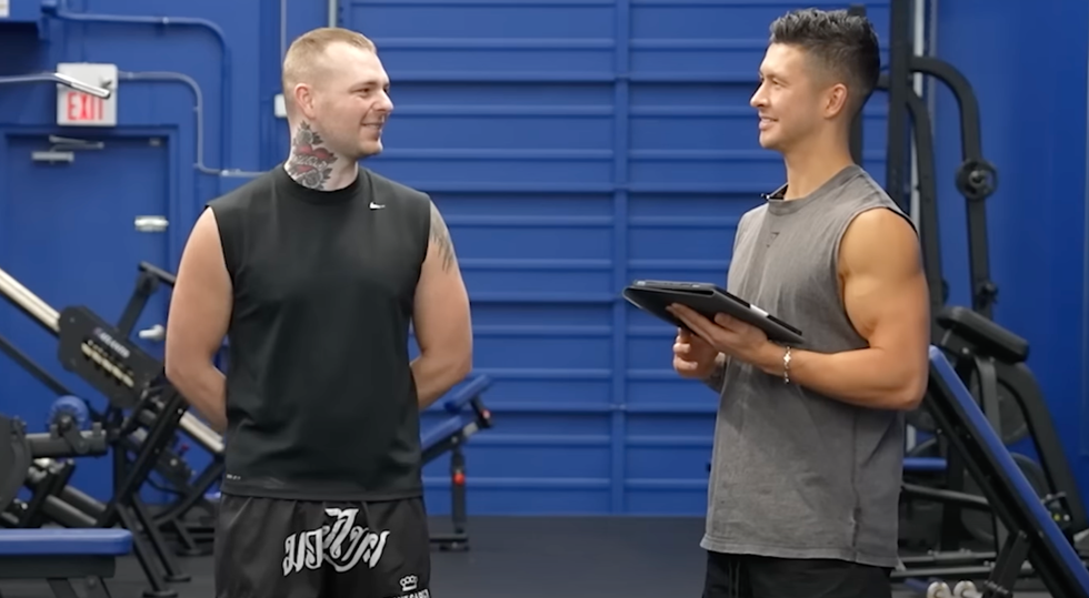 two individuals engaged in a discussion in a gym setting
