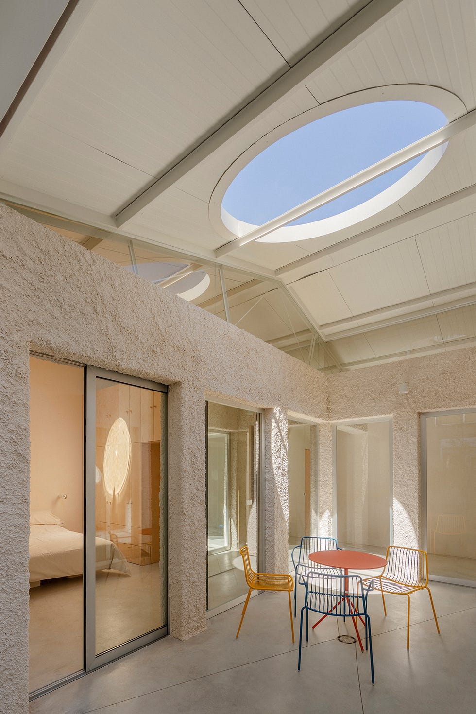 casa moderna con muebles de colores, patio interior y claraboya