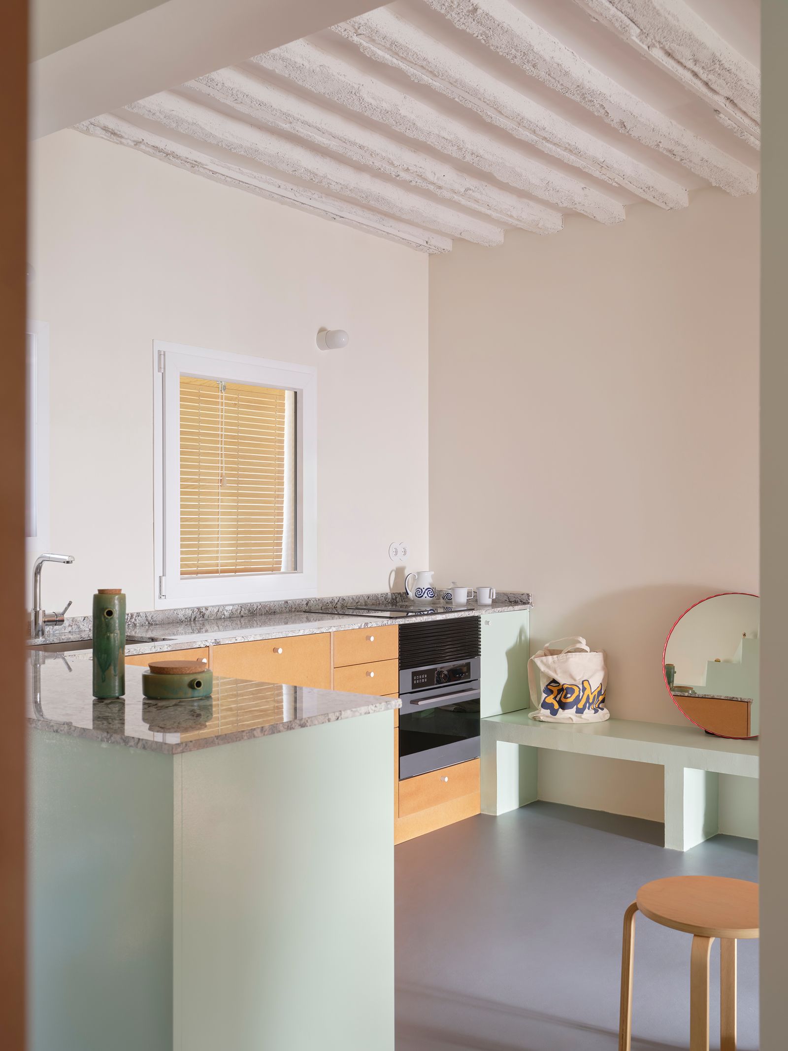 cucina a vista con penisola panca in muratura sgabello in legno travi a vista