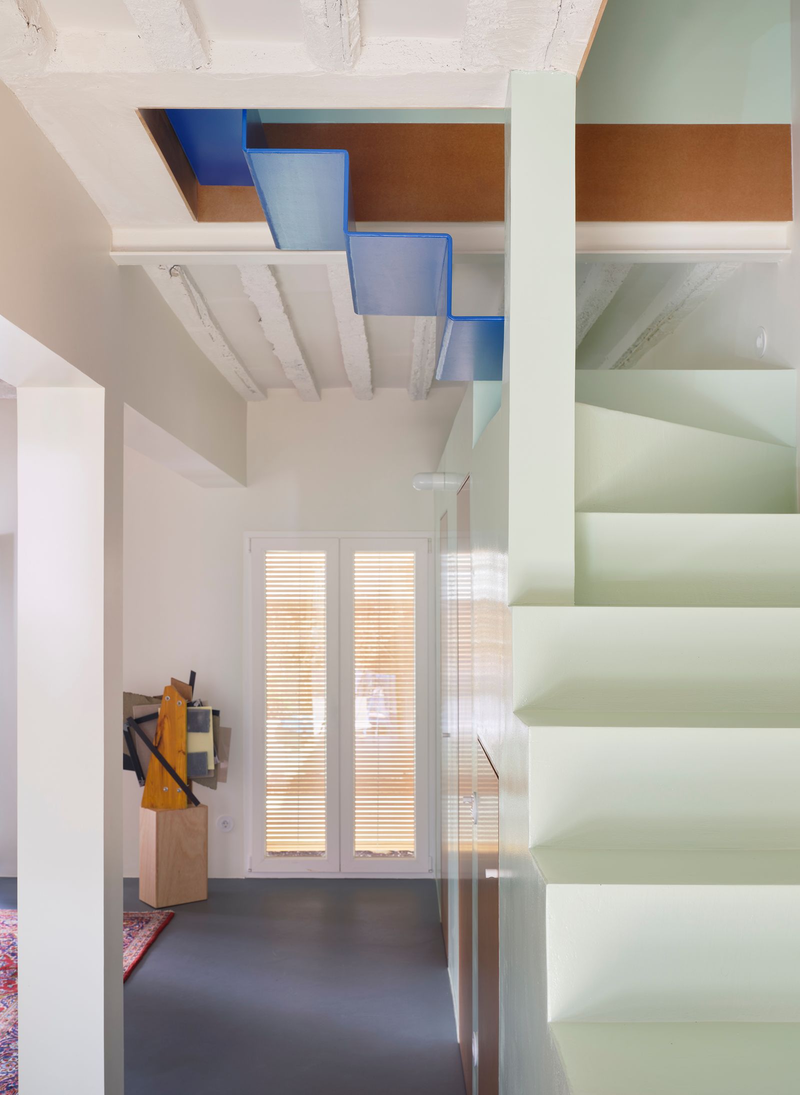 colonna scala bianca con dettaglio blu pavimento in cemento cerato scultura