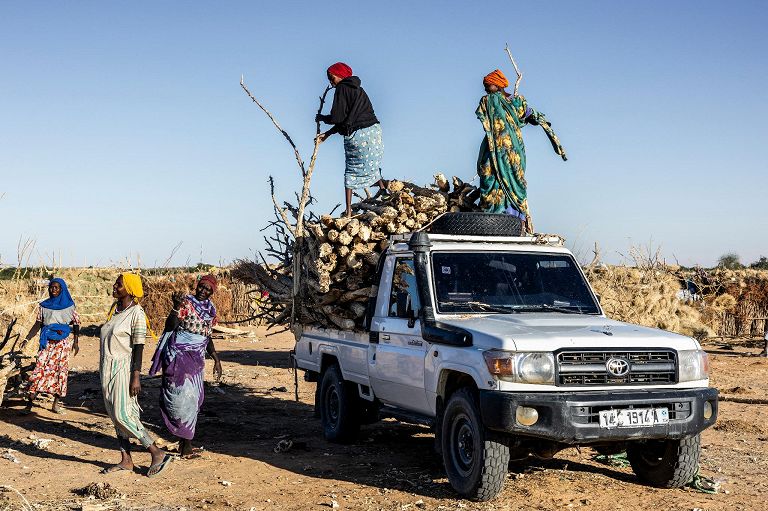 Rifugiati sudanesi scaricano legna da un'auto nel campo di Oure Cassoni, in Ciad, il 14 novembre 2025