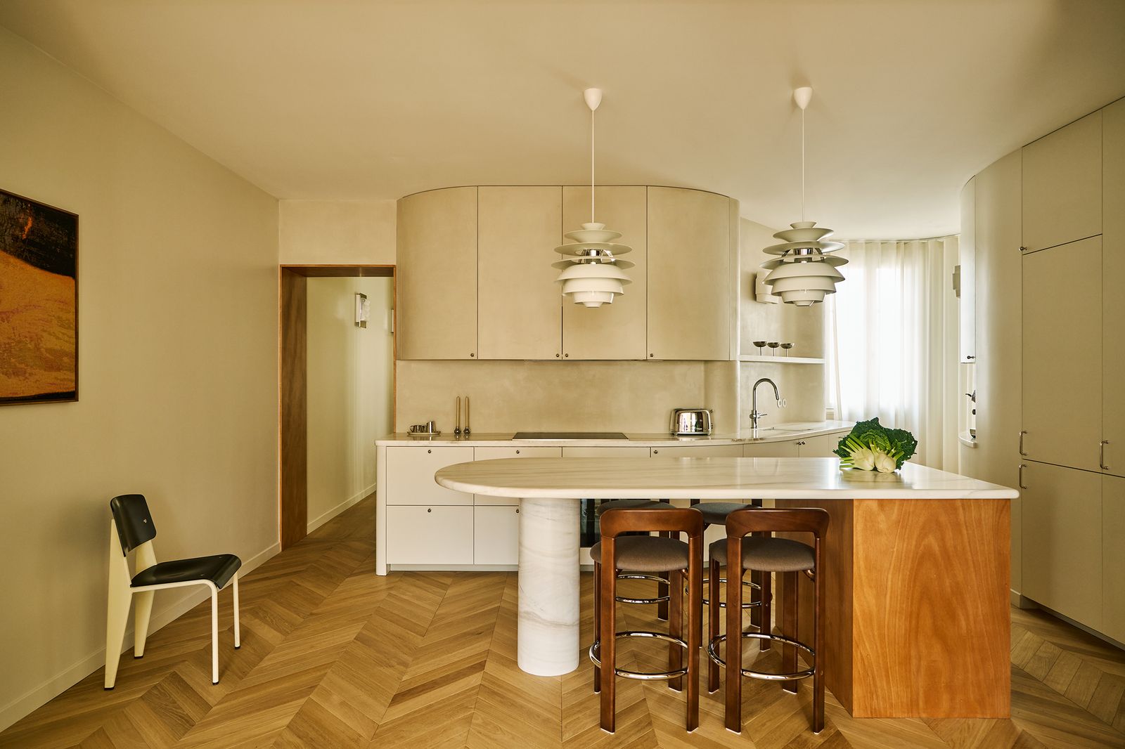 open space living e cucina a vista pavimento in legno a spina di pesce isola curva sgabelli