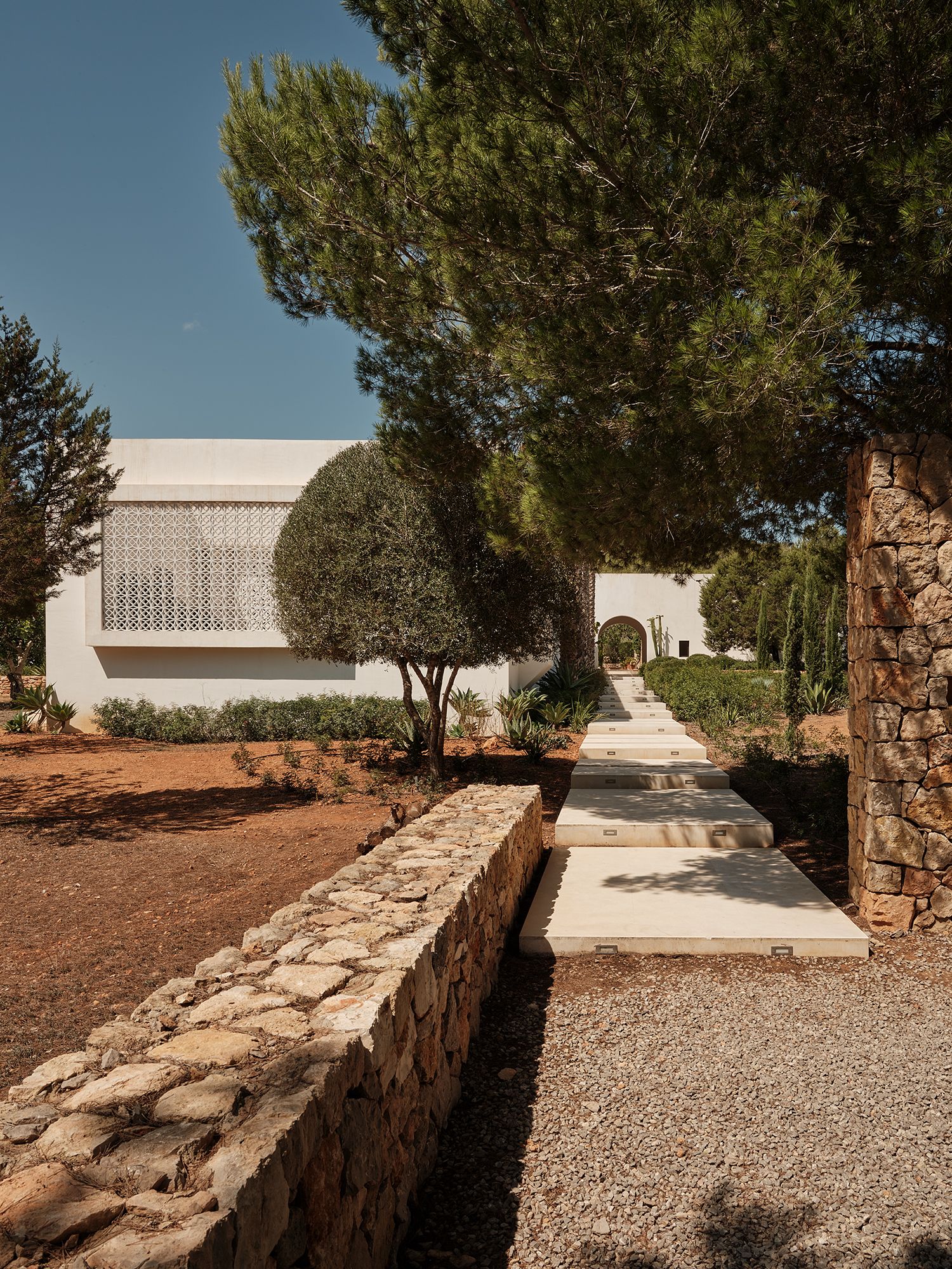 casa a ibiza giardino alberi muretto in pietra gradini ingresso
